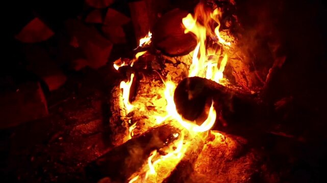 Orange flames on yellow wood in the dark, showcasing intensity and heat. Suitable for firerelated, night scene, or energy themes.