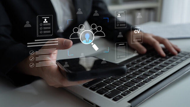 A business professional engages with smartphone and laptop to streamline the recruitment process, showcasing digital tools and data visualization in a modern office environment. Cyphers
