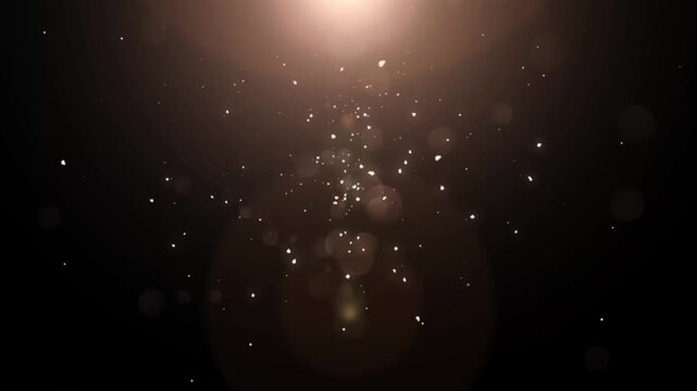 Abstract gold particles floating with elegant bokeh lights and warm lens flare on a black background, seamless loop motion graphic.