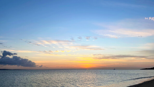 沖縄宇茂佐の海に沈む夕日と穏やかな波打ち際の風景 沖縄県名護市