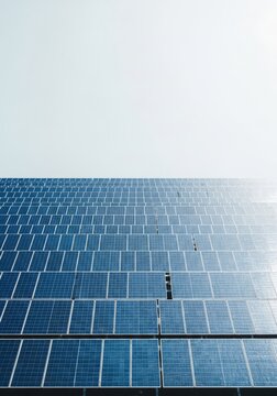 Aerial view of geometric solar panels arranged in a clean pattern with vast negative space for corporate branding and modern typography, solar, blue, layout