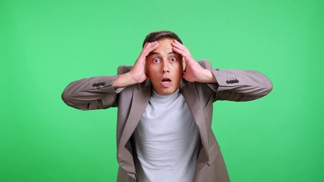 Surprised man gasping in amazement on green screen