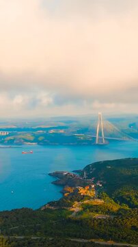 Vertical video. Istanbul, Turkey. Yavuz Sultan Selim Bridge, a hybrid cable-stayed suspension structure with twin A-shaped pylons, Drone footage ascending through clouds at sunset. Drone footage. Ric