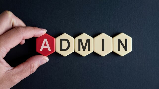 Hand arranging letter tiles to spell ADMIN