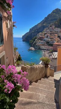 Beautiful scenic view of Positano town on Amalfi Coast in Italy with pink flowers