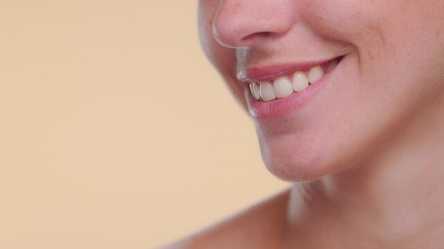 Cropped portrait of Latina with light complexion and freckles smiling over beige bg | face care commercial