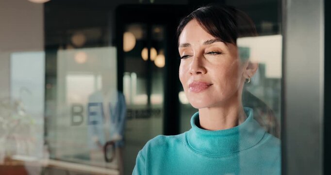 Smile, thinking and business woman in window for idea, inspiration or planning for property. Glass, reflection and commercial realtor with vision for future, happy and looking at real estate