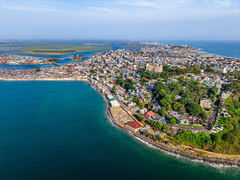 Aerial view of the coastal skyline and urban landscape with dense buildings and lush greenery along the Atlantic Ocean in Monrovia, Montserrado, Liberia.