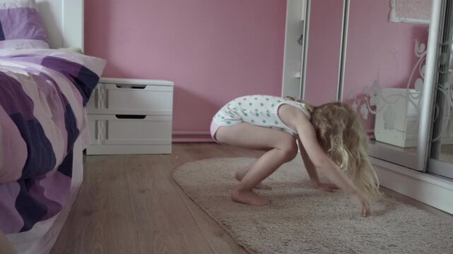 Slow motion, girl jumps from bed to carpet, Little girl slowly jumps from bed to floor,Little girl jumps on carpet near bed in bright bedroom