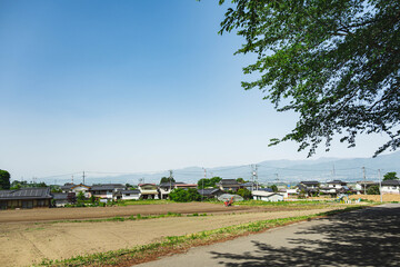 朝日村の閑静な田園風景と遠くの山々 © kikisora