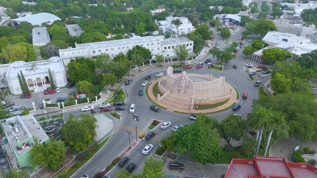 Merida, Yucatan, Mexico: A high-angle aerial landscape shot captures the magnificent Monumento a la Patria, located in a prominent traffic roundabout along the iconic Paseo de Montejo avenue in Merida
