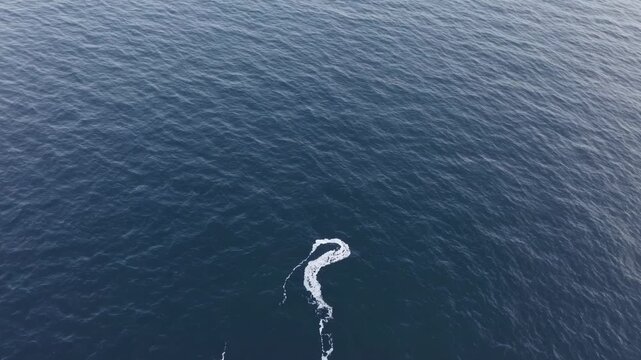 White water trail created by a moving boat on deep blue ocean water, showing continuous motion and direction change across three sequential frames