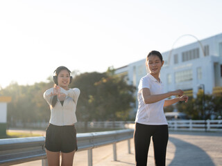 Obraz premium Two Asian woman in sport suit exercise together at stadium