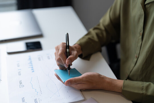 Business man working from home taking reading and writing notes in note.