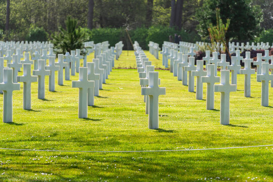 Military memorial cemetery with repeating rows of white grave markers. Honoring fallen soldiers
