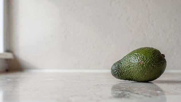 Avocado fruit stone green dark bumpy textured surface landscape close-up framing