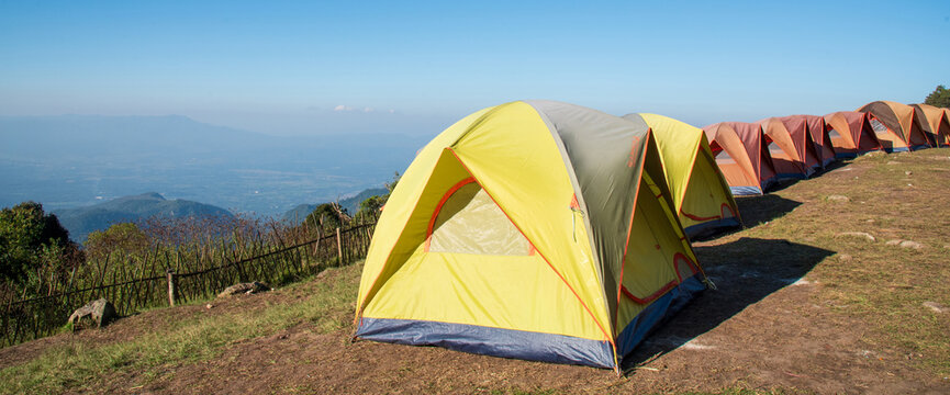 Banner Tent Camping trip outdoor hiking mountain hill. Tent camp in nature background sunrise top mountain. Adventure Travel with copy space. Banner Picnic tent green nature campground forest