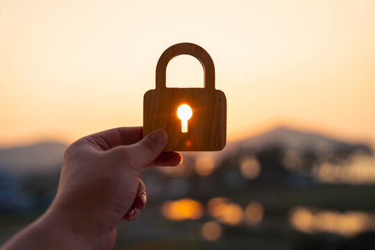 Padlock silhouette with sunset light through keyhole, data security privacy and financial protection concept.