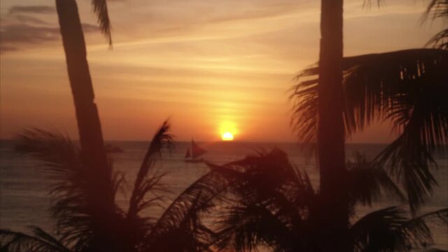 The evening atmosphere is depicted by the sky slowly changing colors from bright orange, golden yellow, to a warm reddish hue as the sun slowly sinks below the horizon.