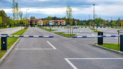 Automatic parking barrier gate closed at empty outdoor car park. Residential area parking lot entrance with boom barrier. © Igor