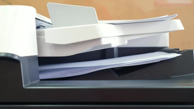 Pile of A4 paperwork documents are print out from photocopy machine in fast motion. 4K footage.