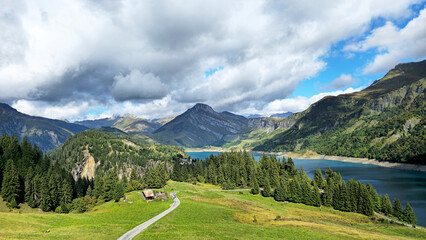 Obraz premium Alpine landscape showing Roselend Lake with road and mountains, Beaufort, Savoie, France, Europe.