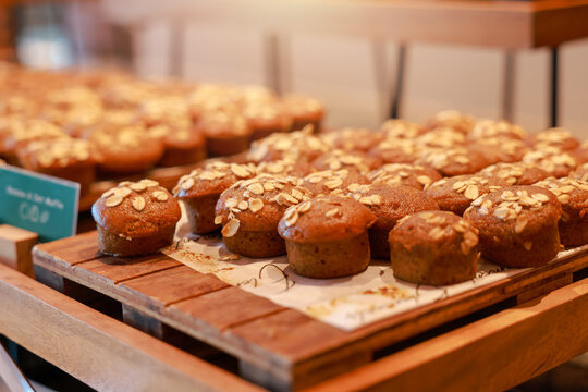 Freshly baked healthy mini banana oat muffins topped with rolled oats on a wooden tray at a luxury hotel breakfast buffet. Delicious sweet bakery dessert pastry for morning brunch food catering.