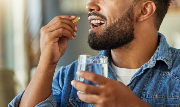 Hands, water and man with medicine at house for health, medical dosage and supplements. Happy, male person and glass with drugs for magnesium, omega 3 and vitamin capsule for healthcare healing