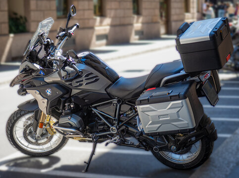 BMW R1250 GS, a maxi-enduro road bike equipped with side cases and a rear top case, parked on a city street. Triple Black version. Milan - Italy, 17 May 2026