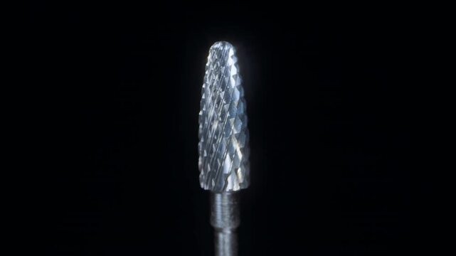 Macro Dolly Slider Shot of Professional Manicure Drill Bit Surface, Extreme Closeup of Sharp Metal Texture With Reflective Details on Black Background