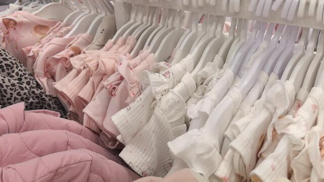 A delightful collection of baby clothes fills the racks in a cozy store. Soft pastels and playful patterns bring joy to shoppers seeking the perfect outfit for little ones.