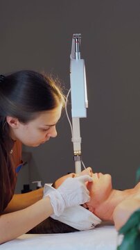 Professional facial cleansing procedure. Vertical video. Therapist performing facial with sterile technique. Clinical spa setting with therapist using sterile methods for facial and impurity removal