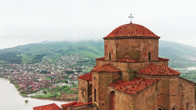 Drone footage capturing historic Jvari Monastery with sweeping river views, mountains and peaceful natural scenery in Georgia.
