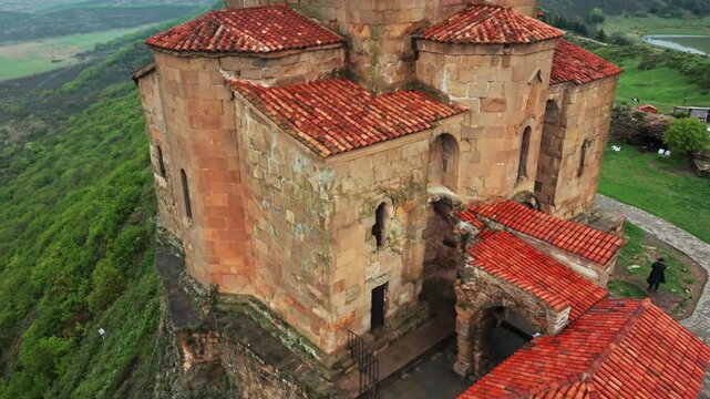 Atmospheric drone shot of Jvari Monastery overlooking dramatic terrain, winding rivers and scenic Caucasus countryside.