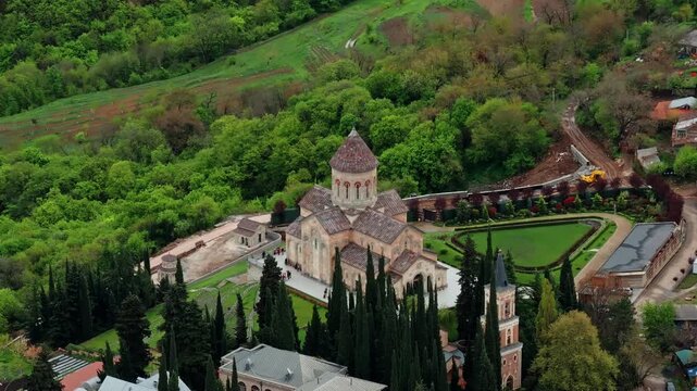 High drone perspective of Bodbe Monastery revealing lush gardens, rolling hills, and expansive views of the Caucasus countryside.