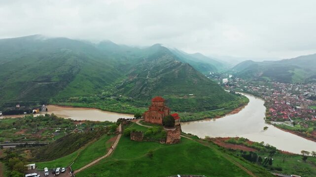 Breathtaking aerial drone footage of historic Georgian monasteries along winding rivers. Explore ancient Orthodox architecture and majestic Caucasus mountain landscapes in 4K.