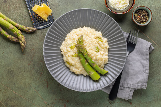 Risotto with asparagus in ceramic plate. Italian Cuisine. Top view
