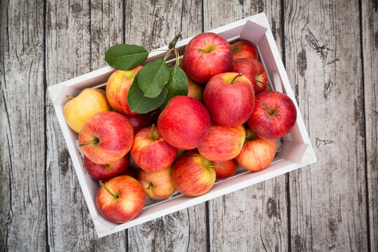 Box of red apples on wood