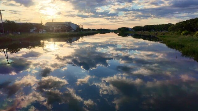 雲がみなもに映る古利根川の日の出の風景
