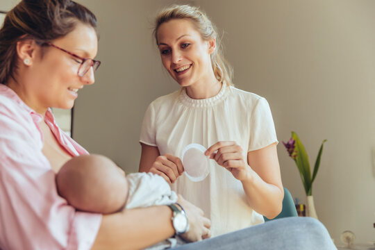 Midwife holding a disposable nursing pad for breastfeeding mother