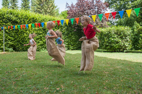 Children having a sack race in garden on a birthday party