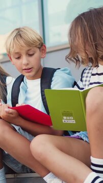 Portrait of smiling cheerful school children that hugging each other and smiling in camera, outdoors. Back to school concept. Slow motion