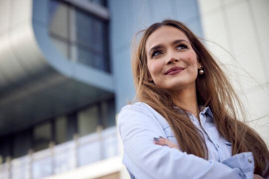 Thoughtful businesswoman looking away while standing outdoors