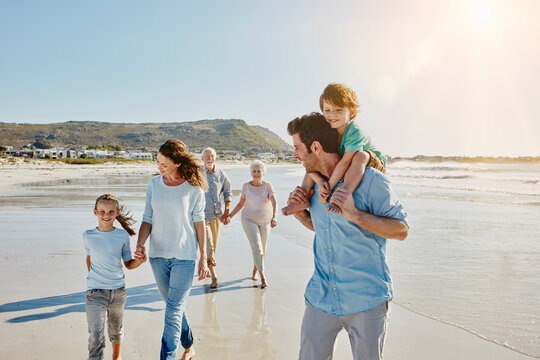 Three generations family strolling on the beach