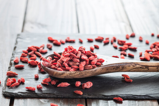 Wooden spoon with goji berries on a slate, superfood
