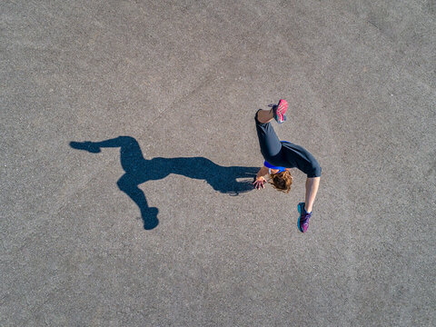 Aerial view of sportive young woman training handstand