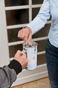 Teenage boy donating money at door