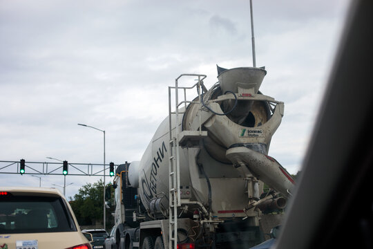 Varna. Bulgaria. 21.05.2026 schwing stetter concrete mixer truck with cyrillic lettering on drum stopped at green traffic light on city road, other cars and street lights visible