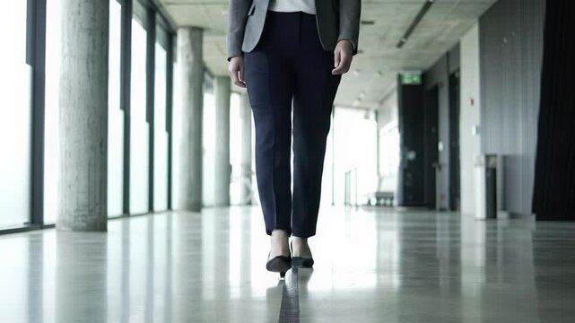 Professional in tailored business-casual attire steps over a threshold on polished concrete, walking into a clean, modern space. high-key natural light creates an optimistic ambiance of strategic new