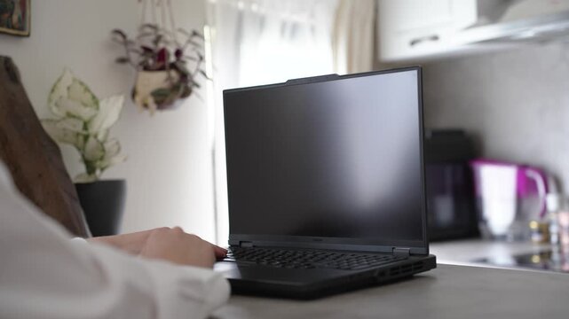 Close-up shot of female hands typing on laptop keyboard in modern workspace. Remote work, online communication, and digital technology lifestyle concept.